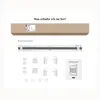 The image shows the contents of a product set, including a long cardboard box, a pleated blind, mounting hardware, and an instruction manual. Produktbild-Vorschau