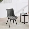 A dark gray chair with a quilted seat and back, and black metal legs, is shown in a room setting with a small round table next to it. Produktbild-Vorschau