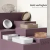 A collection of modern ceramic sinks and decorative bowls displayed on purple tiered platforms against a light background. Voir les images du produit
