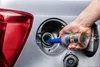 A person is pouring a liquid additive from a can into a car's fuel tank. Produktbild-Vorschau
