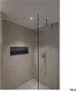 A modern bathroom with a walk-in shower, tiled walls, and a built-in niche. Anteprima dell’immagine prodotto