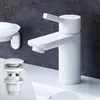 A white bathroom faucet and drain assembly are shown on a white sink against a dark gray textured wall. Produktbild-Vorschau