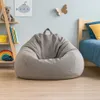 A child's bedroom with a bean bag chair, bed, and shelves. Produktbild-Vorschau