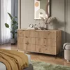 A bedroom scene featuring a wooden sideboard with drawers, a plant, and artwork on the wall. Voir les images du produit