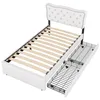 A white upholstered bed frame with a tufted headboard and wooden slats, shown with two pull-out drawers underneath. Podgląd zdjęcia produktu