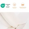 Close-up view of a cream-colored mattress or bedding material, with informational icons and text above. Voir les images du produit
