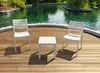 Two white chairs and a white table are placed on a wooden deck next to a pond. Voir les images du produit