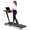 A woman is using a treadmill with a laptop desk attachment. Podgląd zdjęcia produktu