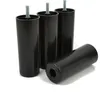 Four black plastic furniture legs are displayed on a white background. Three legs are standing upright with threaded bolts extending from the top, while one leg is lying horizontally in the foreground, revealing a hexagonal opening at one end. Podgląd zdjęcia produktu