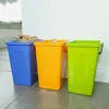 Three recycling bins are lined up against a wall. Podgląd zdjęcia produktu