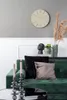 A living room scene with a green sofa, decorative pillows, candles, and a wall clock. Voir les images du produit