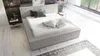 A modern bedroom with a bed, nightstand, and rug. Produktbild-Vorschau