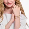 A young girl's arm wearing a charm bracelet. Náhled obrázku produktu