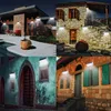 A collage of four images showing solar lights installed on the exterior walls of different houses at night. Produktbild-Vorschau