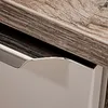 A close-up view of a drawer handle and the edge of a wooden countertop. Produktbild-Vorschau