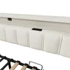 A close-up view of the headboard of a bed, showing integrated charging ports and the upholstered design. The bed frame is partially visible at the bottom. Produktbild-Vorschau