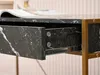 A close-up view of an open drawer on a desk with a marble finish. Voir les images du produit