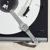 A silver digital watch is placed on a vinyl record on a turntable. Produktbild-Vorschau