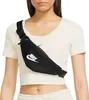 A woman wearing a crop top and sweatpants is modeling a black Nike fanny pack. Náhled obrázku produktu