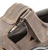 A close-up view of a gray safety sandal, showing the stitching and a brand logo. Produktbild-Vorschau