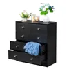 A black dresser with five drawers, one of which is open and contains a blue garment. Decorative items are on top of the dresser. Náhľad obrázku produktu