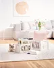 A living room scene with a sofa, coffee table, and decorative items. Produktbild-Vorschau