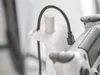 A close-up shot of a white controller holder with a black cable plugged into a controller. Produktbild-Vorschau