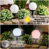 Two images showing solar garden lights in a garden setting. The top image shows the lights charging in the sun, and the bottom image shows them lit up at night. Produktbild-Vorschau