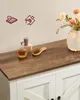 A close-up of a wooden cabinet top with decorative items. Náhled obrázku produktu