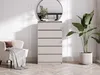 A chest of drawers in a room with a chair and a plant. Voir les images du produit