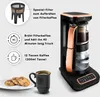 A coffee maker with accompanying text and icons highlighting its features, along with a cup of coffee and cookies. Produktbild-Vorschau