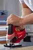 A person is holding a red jigsaw with black accents. Produktbild-Vorschau