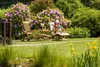 A woman relaxing in a garden on a deckchair, reading a book. Produktbild-Vorschau