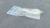 A silver cookie cutter with a handle is packaged in a clear plastic bag, with a blue and white label attached. Produktbild-Vorschau