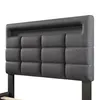 A close-up view of a gray upholstered headboard with a tufted design. Produktbild-Vorschau