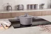 A taupe pot with a glass lid sits on a black induction stovetop in a modern kitchen. Náhľad obrázku produktu