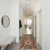 A hallway with a bench, mirror, and a rug. Podgląd zdjęcia produktu