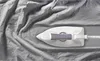 A close-up, overhead shot of a white and gray iron resting on rumpled gray fabric. Produktbild-Vorschau