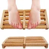 A pair of feet resting on a wooden foot massager. Náhľad obrázku produktu