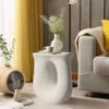 A modern living room scene with a white sculptural side table. Náhled obrázku produktu