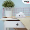 A cloud-shaped night light sits on a white table next to a potted plant. Voir les images du produit