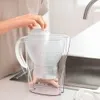 A person is placing a filter into a water pitcher. Podgląd zdjęcia produktu