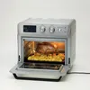 A silver air fryer oven with a chicken and potatoes inside, on a white background. Podgląd zdjęcia produktu