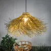 A solar pendant lamp with a natural, boho-inspired design is shown hanging above a woven tray with two cups and saucers. A lush green plant is visible to the left. Produktbild-Vorschau