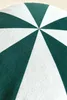 A close-up view of a round cushion with a green and white starburst pattern. Podgląd zdjęcia produktu