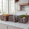 Three wooden crates filled with produce and herbs on a kitchen counter. Náhled obrázku produktu