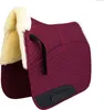 A burgundy saddle pad with cream-colored sheepskin lining and black accents, shown against a white background. Produktbild-Vorschau