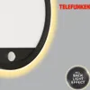 Close-up of a black LED outdoor light with a motion sensor and a glowing yellow backlight effect, with the Telefunken logo in the top right corner. Produktbild-Vorschau