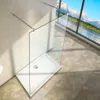 A modern walk-in shower enclosure with a glass panel and a white shower tray, set against a tiled wall and a large window with a scenic mountain and lake view. Produktbild-Vorschau