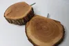 Two wooden discs with visible tree rings and bark, each with a screw protruding from the back, are placed on a white surface. Produktbild-Vorschau
